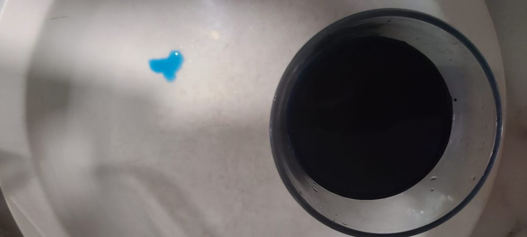 Methylene Blue in a glass and a drop of Methelene blue showing how blue it is